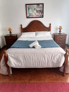 a bedroom with a large bed with a blue and white comforter at Propriedade dos Seixos in Moledo