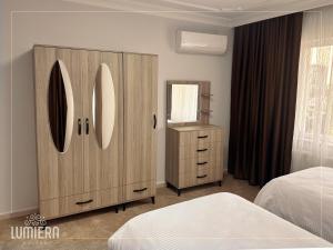 a bedroom with a large wooden cabinet and a mirror at Lumiera Suites Hotel in Nilüfer