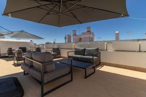 un patio con sillas y una sombrilla en el techo en Allo Apartments San Roque 3ºB, en Cádiz