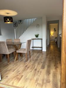 ein Wohnzimmer mit einem Tisch, Stühlen und einer Treppe in der Unterkunft Pine Lodge - Two Bedrooms, High Bickington close to Umberleigh , Barnstaple , Bideford in High Bickington