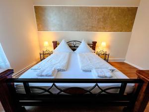 不来梅港Hafen 12的卧室里有一张床，床单和枕头都是白色的