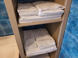 - un porte-serviettes en bois avec des serviettes blanches dans la salle de bains dans l'établissement Villa Manfridi – 10 minuti da Polignano e Monopoli, à Monopoli