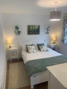 1 cama blanca en una habitación con 2 mesas en Pine Lodge - Two Bedrooms, High Bickington close to Umberleigh , Barnstaple , Bideford, en High Bickington