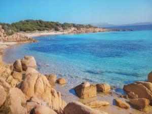 a beach with rocks and the blue water at B&B Meladormo in Tempio Pausania