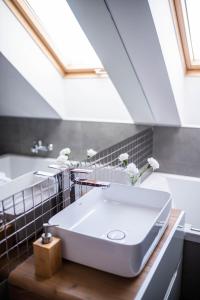 y baño con lavabo blanco y bañera. en Apartamenty Wielbarska, en Szczytno