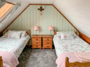 a attic bedroom with two beds and two lamps at The House On The Point - Uk43807 in Kylerhea
