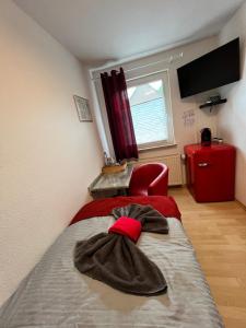 a bedroom with a bed with a red chair at Pension K.Krause in Salzgitter
