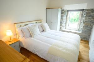 a bedroom with a large white bed with a window at Killarney Old School Road sleeps 6 in Killarney