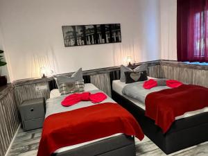 ザルツギッターにあるPension K.Krauseのベッド2台 ホテルルーム 赤いシーツ付