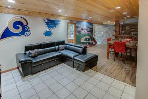 Una sala de estar con un sofá de cuero negro y una mesa. en Spacious Tranquility with Private Pool home, en Belleville