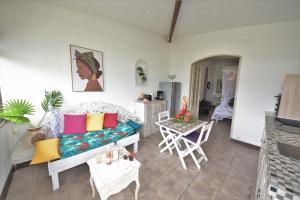 ein Wohnzimmer mit einem Sofa und einem Tisch in der Unterkunft Anoli Lodges in Sainte-Anne