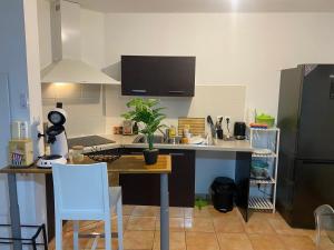 eine Küche mit einem Tisch und einem Kühlschrank in der Unterkunft Charmant T2 - Moufia Sainte-Clotilde vue Mer & Montagne in Saint-Denis