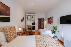 a bedroom with a bed and a living room at Impar Studios Deluxe in Porto