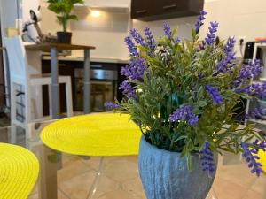 een vaas gevuld met paarse bloemen naast een tafel bij Charmant T2 - Moufia Sainte-Clotilde vue Mer & Montagne in Saint-Denis