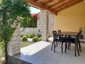 un patio con mesa y sillas bajo un techo de madera en Apartment Lavanda, en Tar