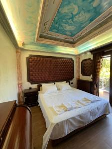 a bedroom with a large bed with a painting on the ceiling at Villa Ioanna Oxylithos, Kymi in Oxílithos