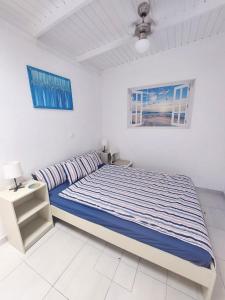a white bedroom with a bed and a window at Brisa Marina - Vista Golf 2 - WiFi - swimming pool in Caleta De Fuste