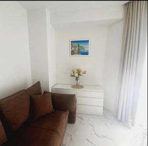 uma sala de estar com um sofá e um vaso de flores em Sirius apartaments em Rafailovici