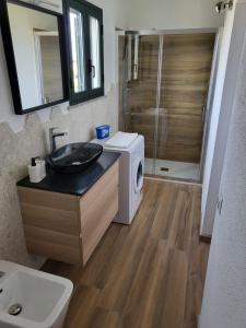 a bathroom with a sink and a washing machine at Paule mare in La Caletta