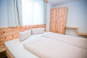 a bedroom with a large white bed and a window at Pension Fuchs in Pfunds