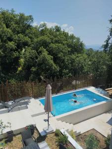 uma piscina com duas pessoas a nadar nela em Once Upon a Time in Montenegro em Sutomore