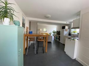 una cucina con tavolo in legno e elettrodomestici bianchi di Maison de ville centre historique Fontaine Les Dijon a Fontaine-lès-Dijon
