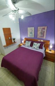 a purple bedroom with a large bed with two pillows at Balcón Atlantida in Candelaria