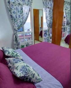 a bedroom with a bed with pillows and a window at Balcón Atlantida in Candelaria
