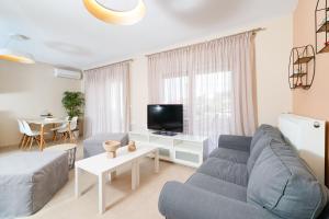 sala de estar con sofá y TV en Nefeli Fresh guesthouses by Del Mare en Prinos