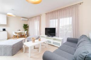 un soggiorno con divano e TV di Nefeli Fresh guesthouses by Del Mare a Prinos