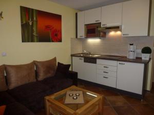ein Wohnzimmer mit Sofa und eine Küche in der Unterkunft Family Apartments Tom in Ostseebad Karlshagen + 75 Fotos