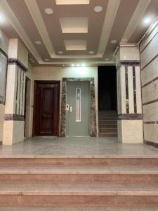 an empty lobby with a green door and stairs at Azzam Guest House 2 families only in Fayoum Center