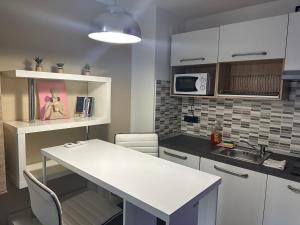 eine Küche mit einer weißen Arbeitsplatte und einem Waschbecken in der Unterkunft FEEL - Vivid Apartment in Bergamo