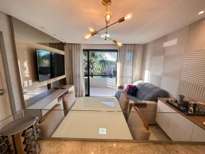 Happy Living Resort في فورتاليزا: غرفة معيشة مع طاولة زجاجية وأريكة