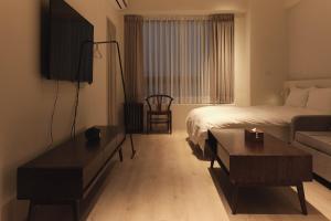 Cette chambre comprend un lit et une table basse. dans l'établissement Yueshe House, à Jiaoxi