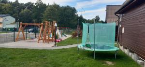 a playground with a swing set and a play yard at M&M Apartamenty Wicie in Wicie