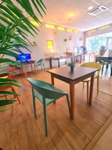 a room with tables and chairs and a plant at Le Cheval Blanc in Arles