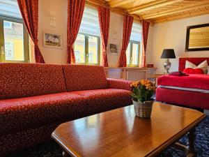 ein Wohnzimmer mit einem roten Sofa und einem Tisch in der Unterkunft Cityappartement am Goethehaus in Weimar