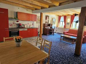 eine Küche und ein Wohnzimmer mit einem Holztisch und einem Esszimmer in der Unterkunft Cityappartement am Goethehaus in Weimar
