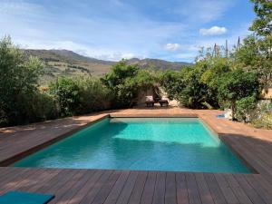 una piscina in un cortile con terrazza in legno di VILLA BLEUE - LES PINS a Port-Vendres