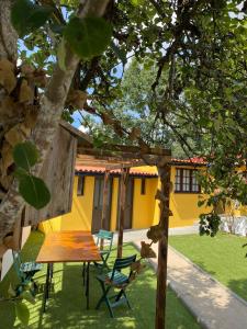 a table and chairs under a tree in a yard at Vila Aurora in Luso