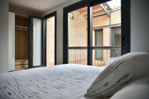 a bedroom with a bed with a large window at Cal Teca Rural in Sant Antolí i Vilanova