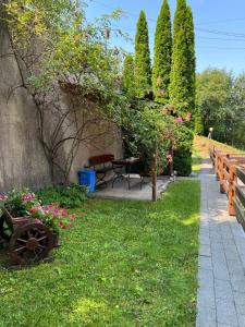 a garden with a bench and flowers in the grass at Casa Dan in Sovata