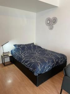1 cama con edredón azul en un dormitorio en Escapade Moretaine - Cosy Studio en Moret-sur-Loing