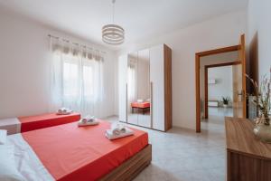 um quarto com 2 camas vermelhas e um espelho em Angolo 31 em Trapani
