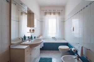 uma casa de banho com 2 lavatórios, uma banheira e um WC. em Angolo 31 em Trapani