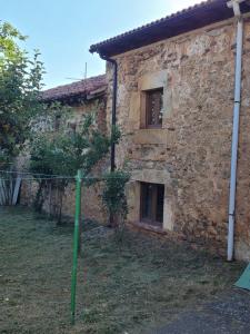 an old stone house with a green pole in front of it at LA CARABA 