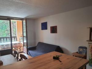 - un salon avec une table en bois et un canapé dans l'établissement T3 au calme rez de jardin station LA COLMIANE, à Valdeblore