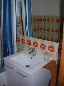 La salle de bains est pourvue d'un lavabo blanc et d'un miroir. dans l'établissement T3 au calme rez de jardin station LA COLMIANE, à Valdeblore