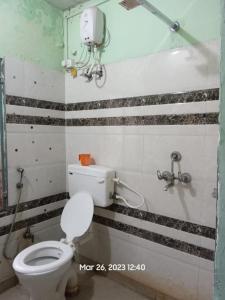 a bathroom with a white toilet in a room at Superinn home stay& guest house in Agra